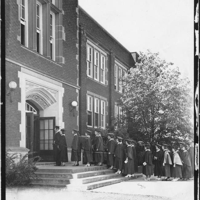 graduates walking into Schofiled for Commencement 